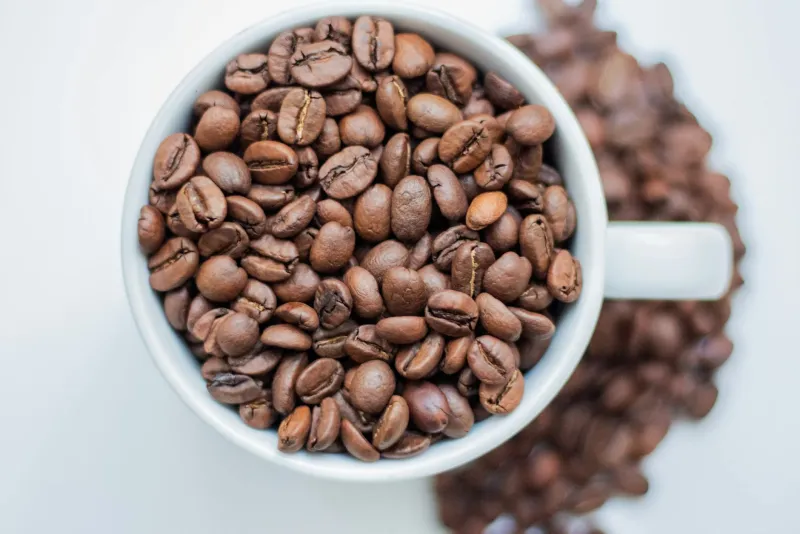 Caffeine capsules and coffee beans representing energy and sports supplement concept