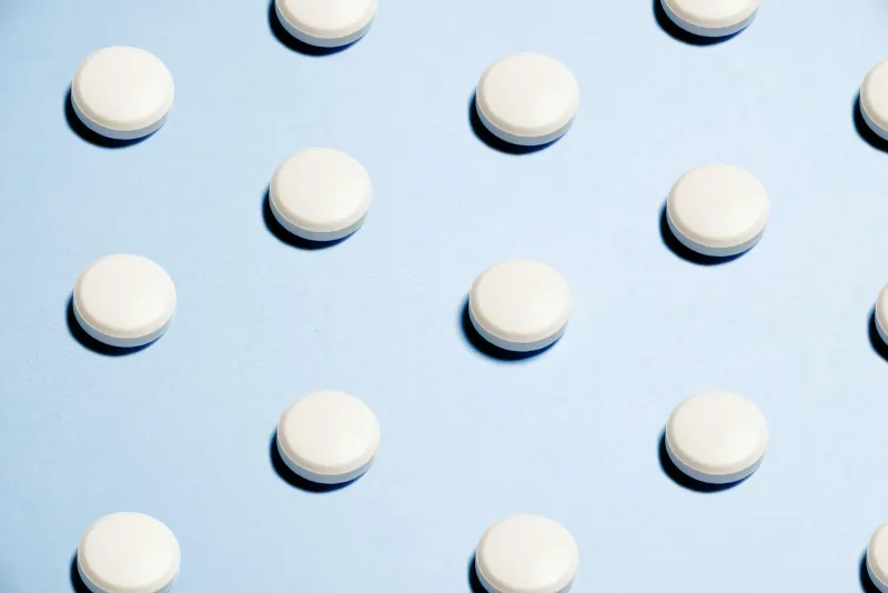 Supplement capsules and powder on a table representing inositol stacking
