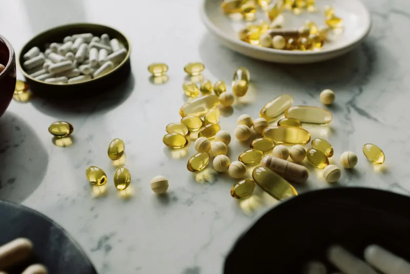 Alpha-lipoic acid ALA capsules on a wooden surface, antioxidant supplements