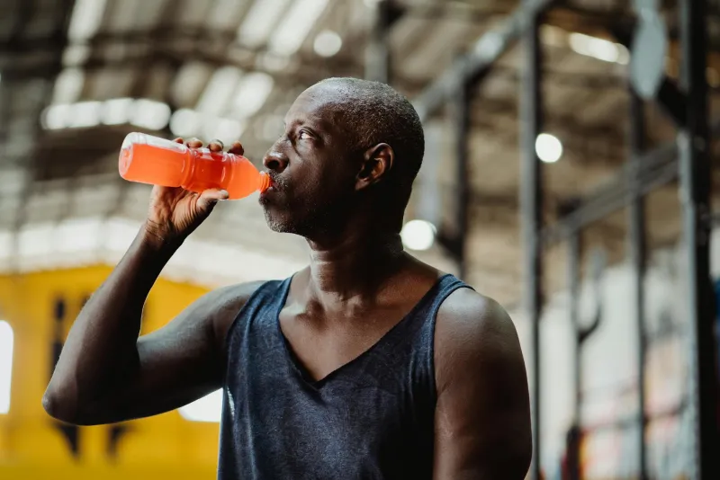 Athlete drinking an isotonic drink during a running training session