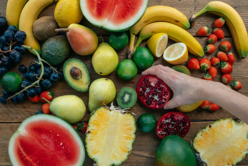 Assorted nuts, seeds, and green vegetables – vegan sources of vitamin E displayed on a wooden surface