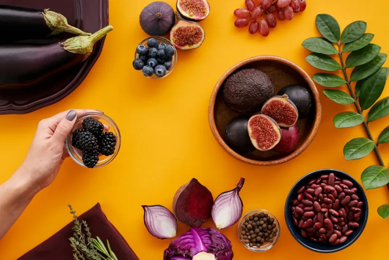 Quercetin-rich foods including onions, apples and berries on a wooden board