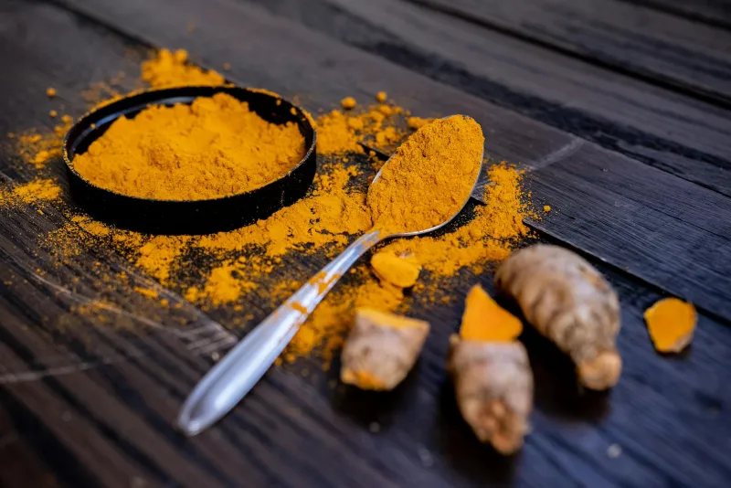 Turmeric root and black pepper on a cutting board – curcumin supplements