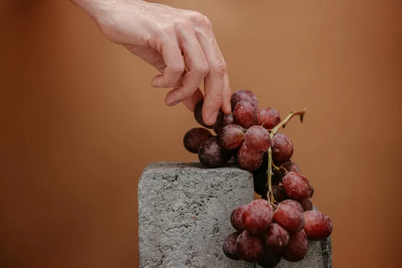 Grape clusters alongside resveratrol capsules against a healthy lifestyle background