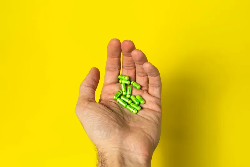 Men's health supplements with natural ingredients on wooden surface