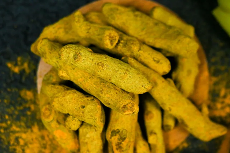 Curcumin capsules and black pepper seeds on a table