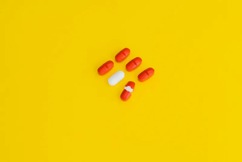 Coenzyme Q10 capsules next to a heart model on a desk