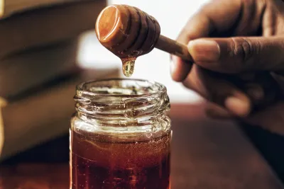 Amber omega-3 fish oil softgel capsules spilling from a glass bottle