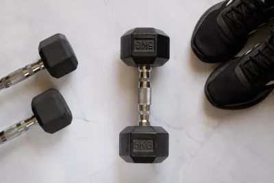 Pre-workout powder being scooped into a shaker bottle on a gym bench