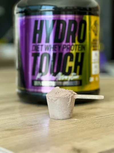 Protein powder jar and spoon on a table - mass gainer supplement
